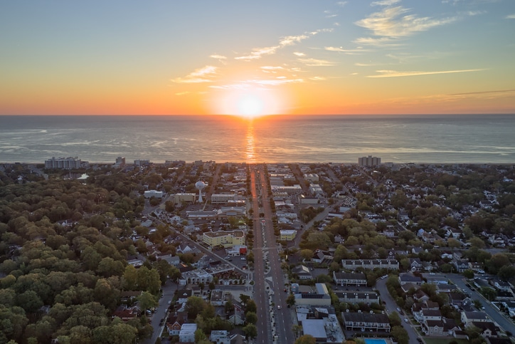 Photo shows sunrise at Rehoboth Beach where the sun is brighting the town. Photo was taken with a drone during summer and the sky is colorful.