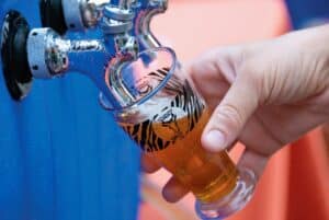 Summer Ale Festival hand pouring beer into a cup.